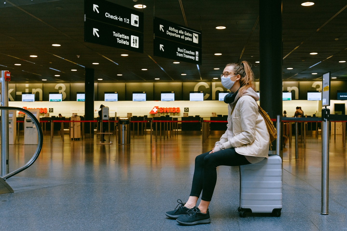 Traveller sitting on a suitcase in an airport